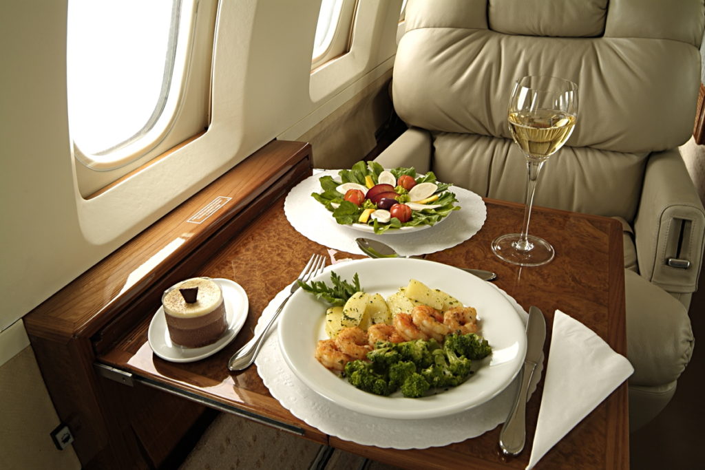 service on board plates of food and drink on tray table